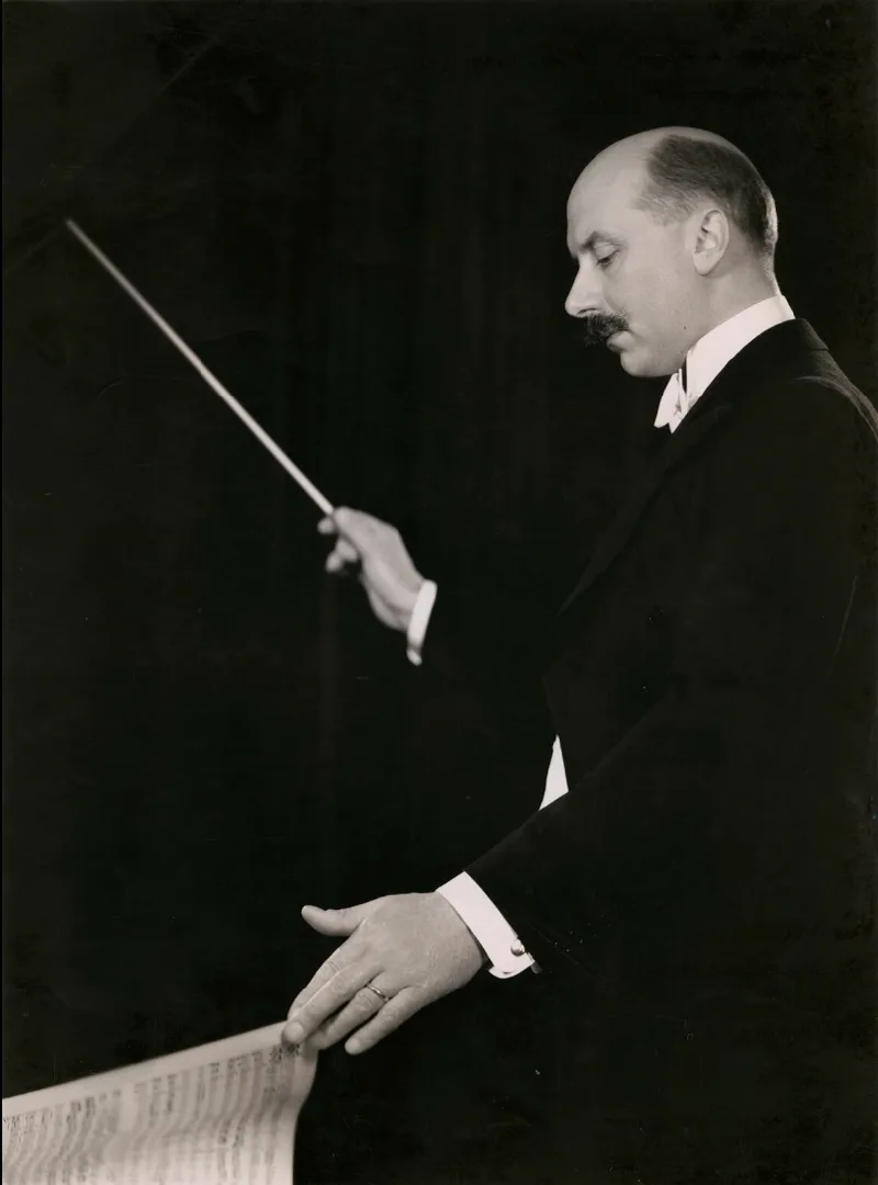 Sir Adrian Boult conducting, baton raised, in a 1935 studio portrait