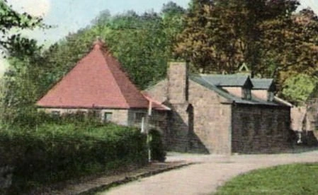 An early hand-tinted postcard view of the museum building and the old school beside St Bridget's churchyard, West Kirby